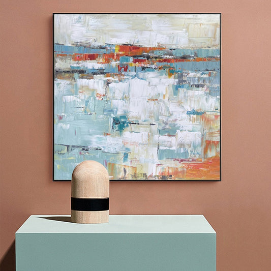 Abstract painting on a wall with a cylindrical wooden object in front