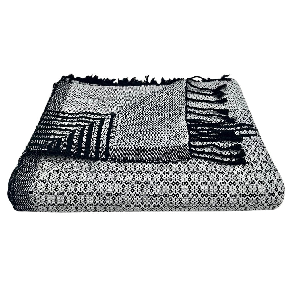 Silver and black Cambodian woven throw draped over modern sofa