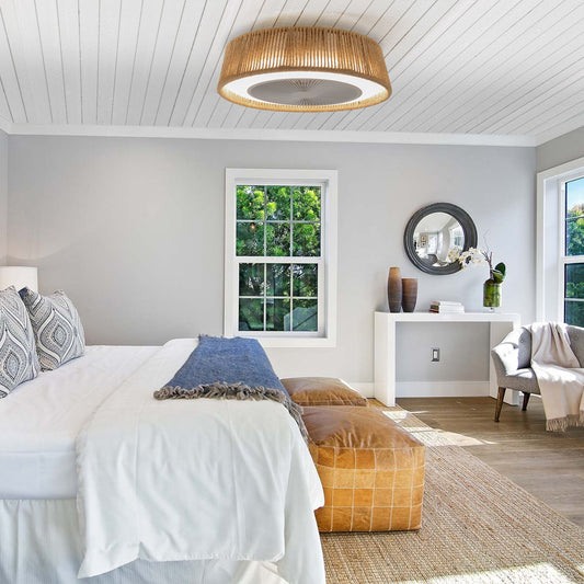 Modern bedroom with a bed, ottoman, and decorative items.