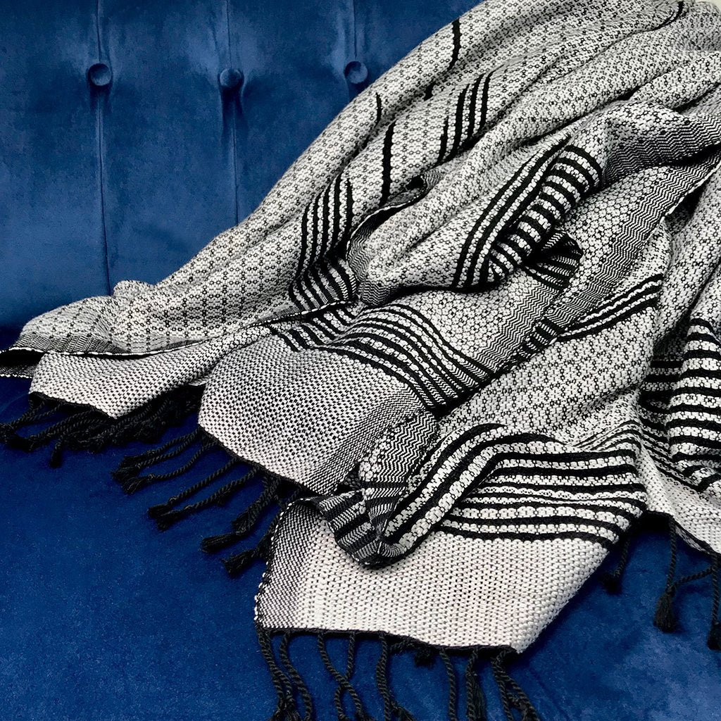 Silver and black Cambodian woven throw draped over modern sofa