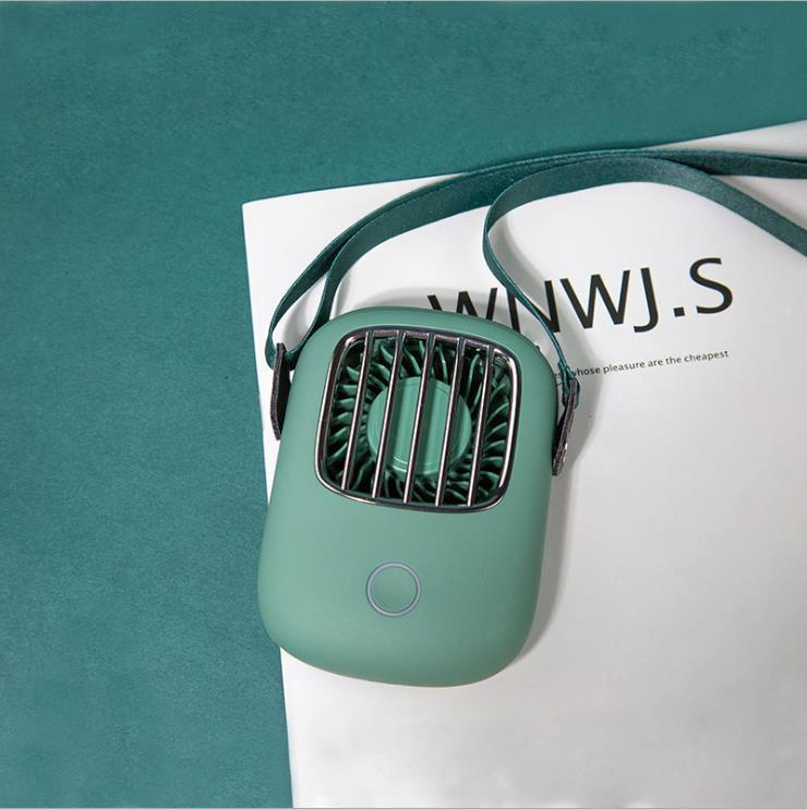 Green handheld fan on a magazine with a teal background