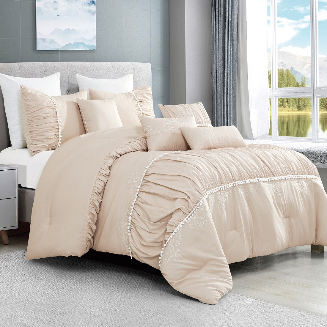 Beige comforter set on a bed in a bright bedroom with large windows.