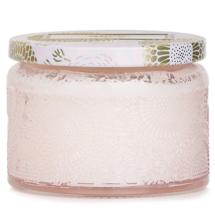 Jar with textured surface and decorative lid on a white background