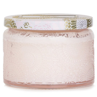 Jar with textured surface and decorative lid on a white background