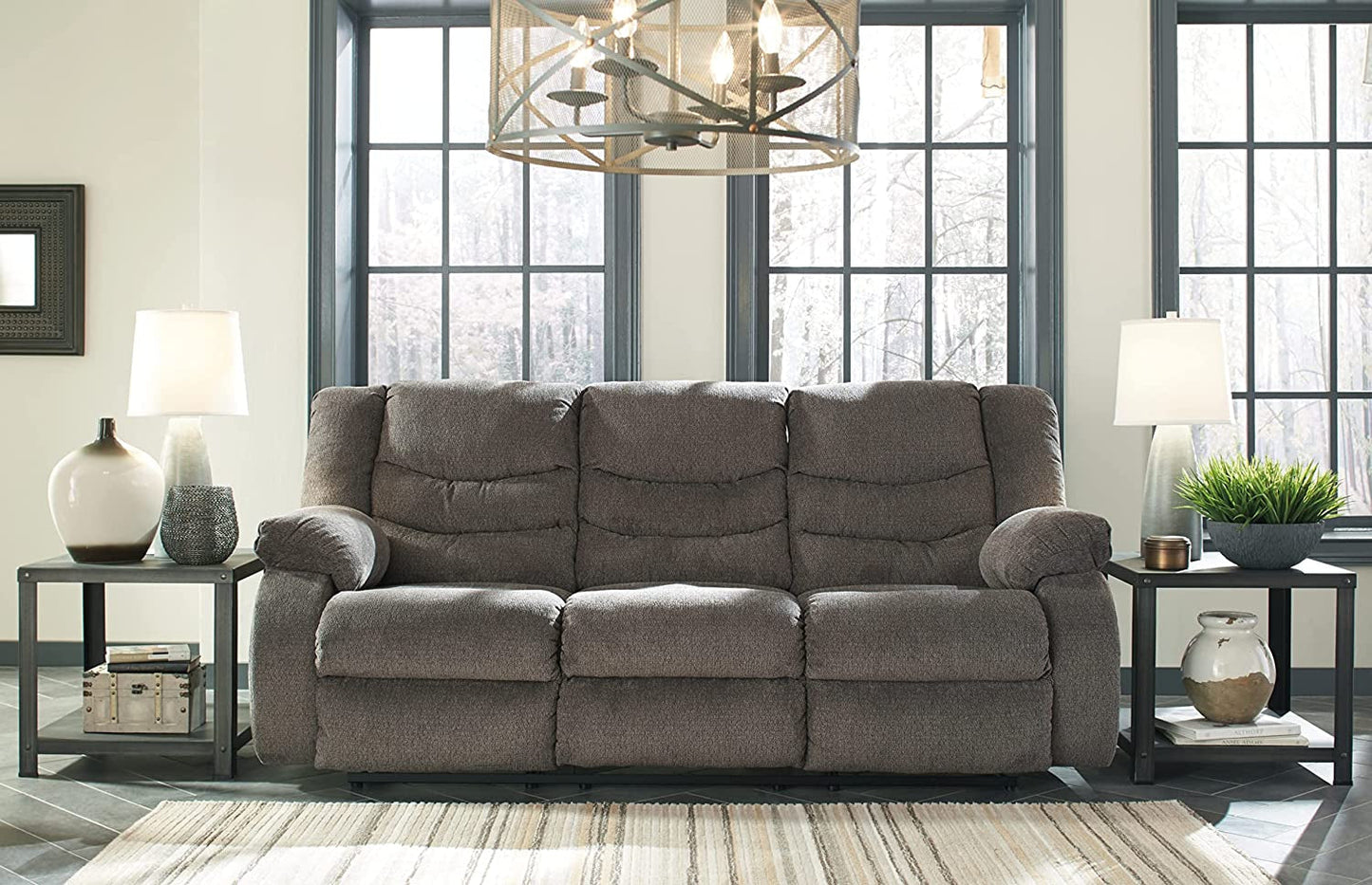 Gray sectional sofa in a living room setting with windows and decor.