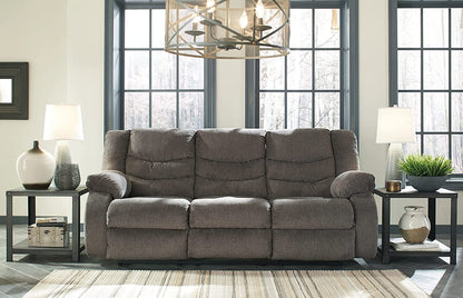 Gray sectional sofa in a living room setting with windows and decor.