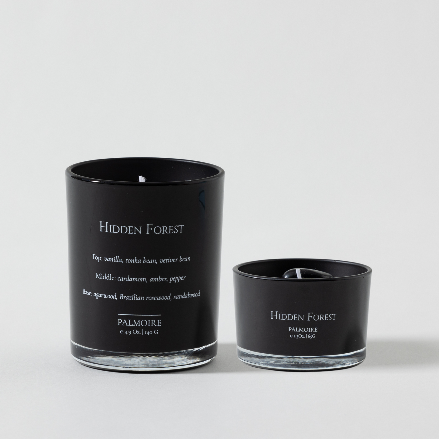 Black candle with 'Hidden Forest' branding on a white background