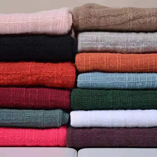 Stack of folded fabric swatches in various colors.