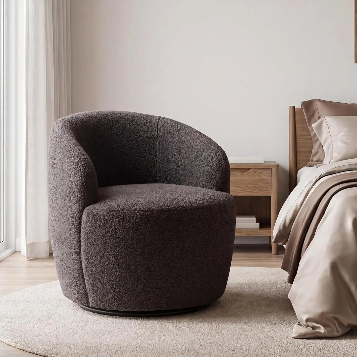 A modern round barrel chair upholstered in dark brown bouclé fabric, set in a minimalist bedroom next to a wooden nightstand and bed.