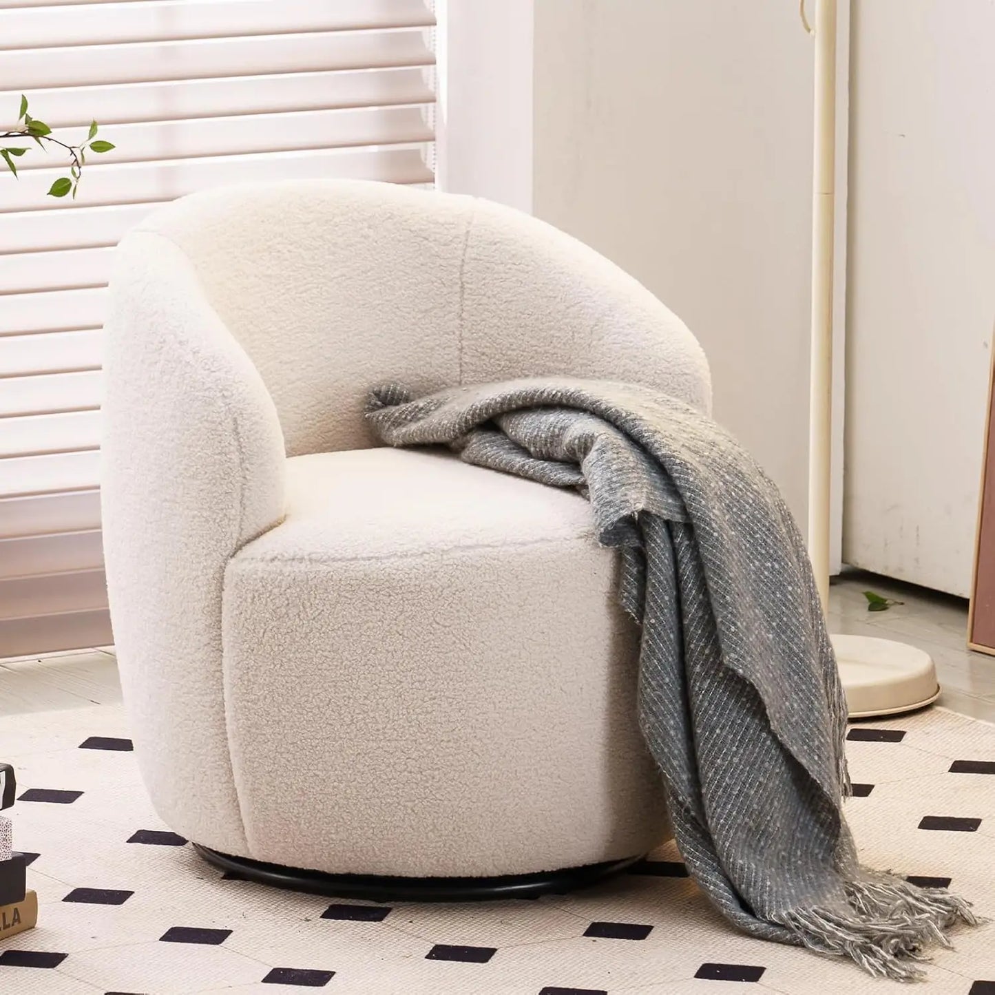 White armchair with a gray blanket in a room with a checkered floor and white walls.
