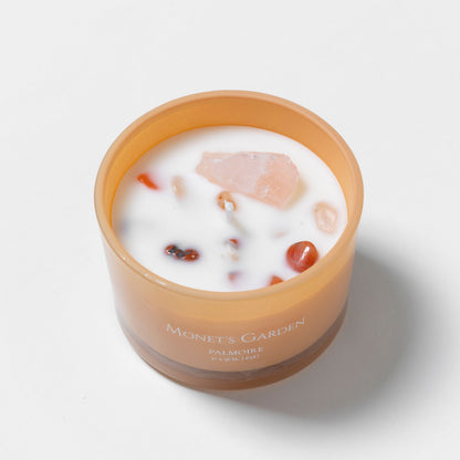 Candle in a brown jar with visible ingredients on a white background