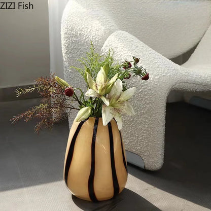 Decorative vase with flowers on a surface with a textured white chair in the background.