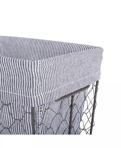 Close-up of removable gray striped fabric liner fitted over an antiqued chicken-wire-style metal basket.