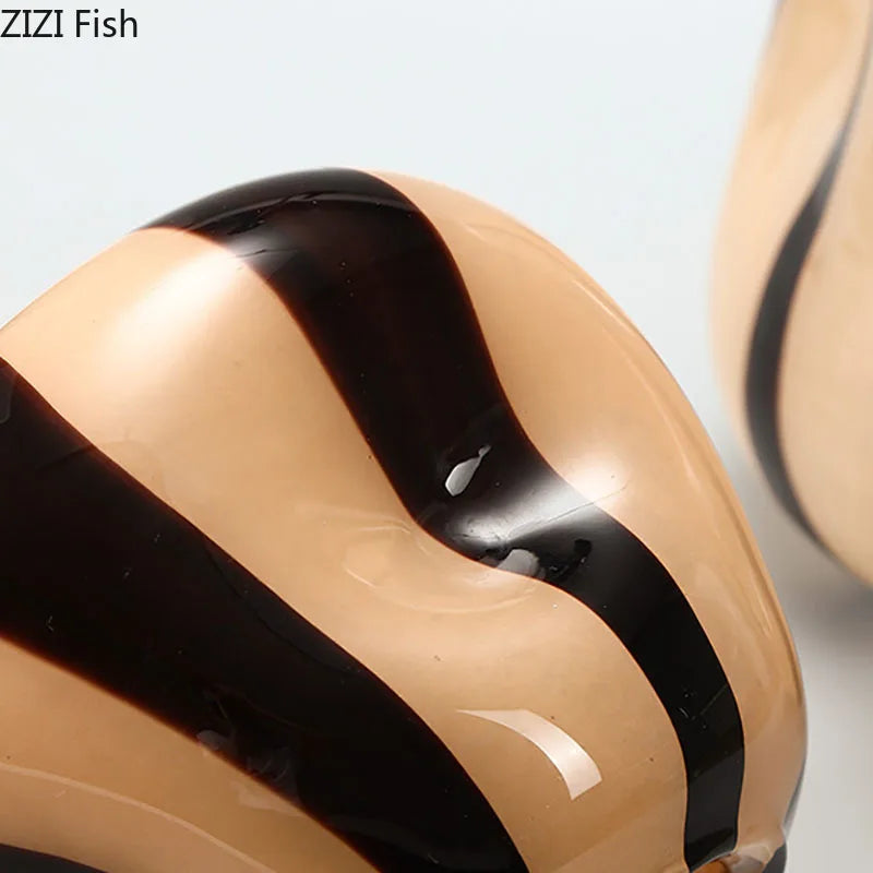 Close-up of a glossy ZIZI Fish decorative fish figurine with a beige body and bold black wavy stripes, set against a light gray background.