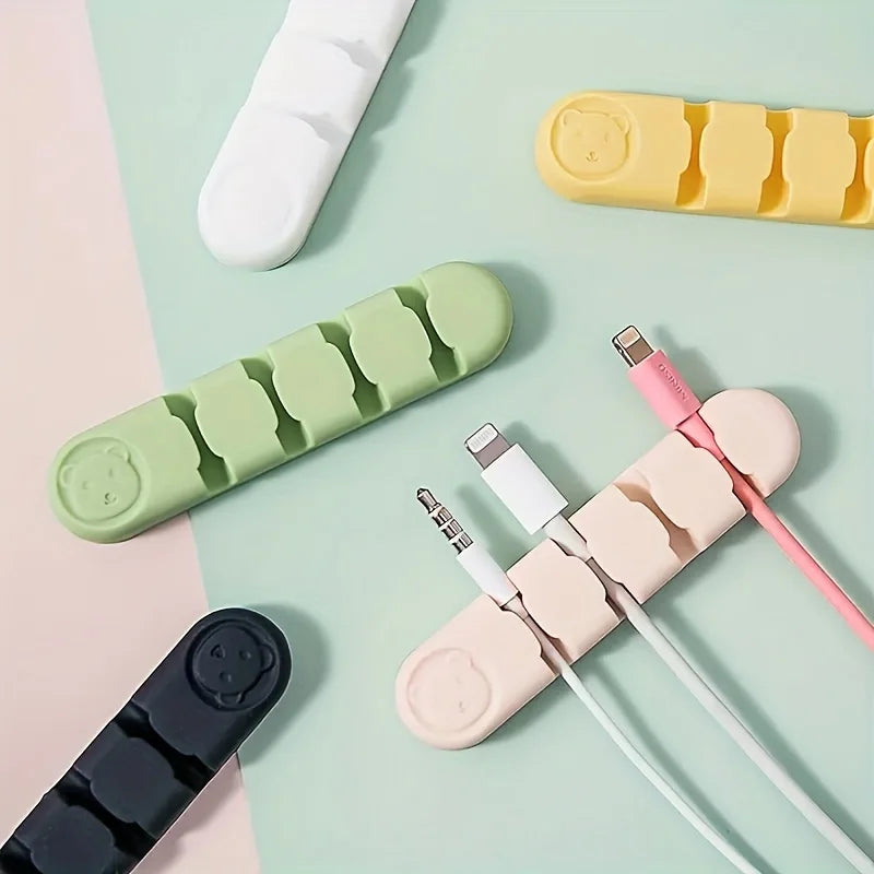 Colorful cable organizers on a pastel background