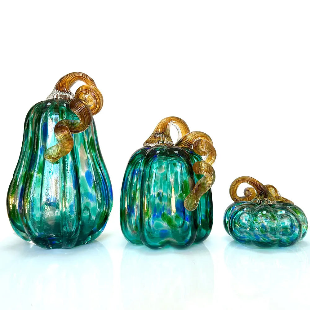 Three green glass pumpkins with gold accents on a white background