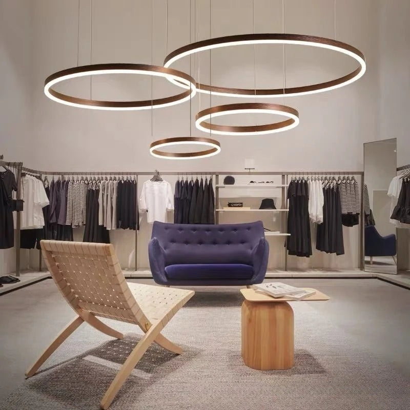 Modern interior design with circular pendant lights, furniture, and clothing racks.