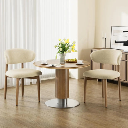 Set of four beige upholstered wood dining chairs around a modern dining table in a warm neutral kitchen.