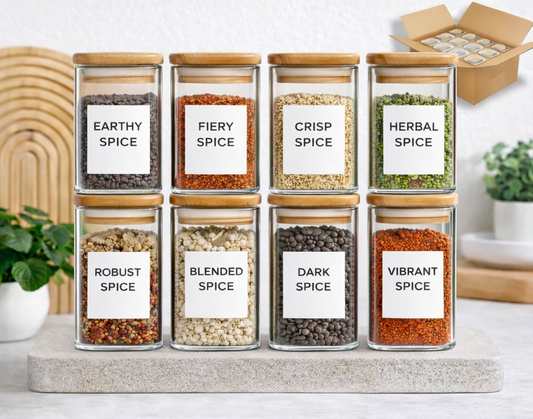 Set of glass spice jars with labels on a kitchen counter