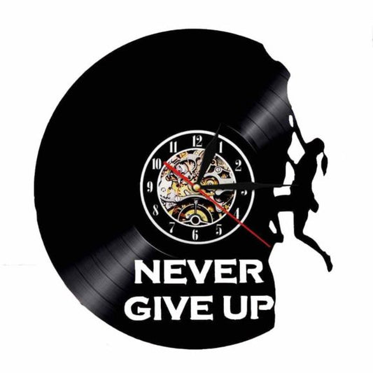 Wall clock made from a vinyl record with a silhouette of a person climbing a mountain and 'Never Give Up' text.