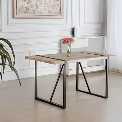 Modern dining table with wooden top and black metal legs in a room with white walls and a plant.