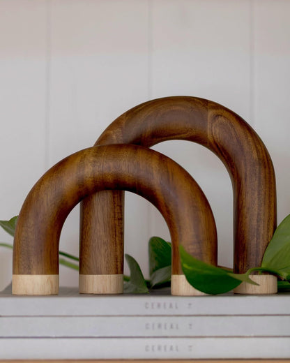 Wooden arch-shaped objects on a surface with a neutral background