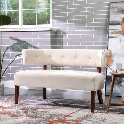 Beige tufted bench in a room with gray tiled wall and decorative rug