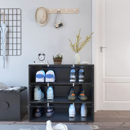 Black shoe rack with shoes on a wooden floor in a room.