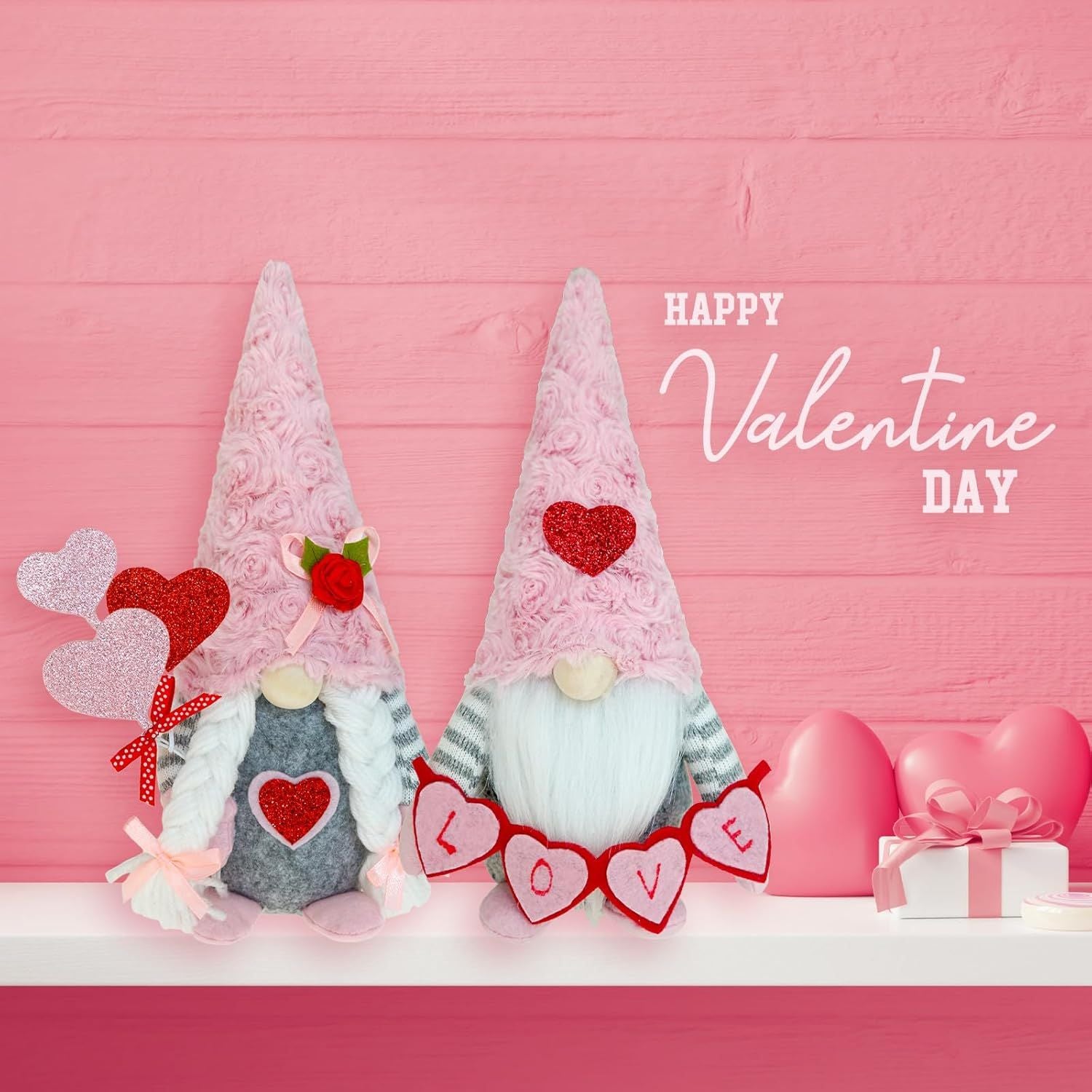 Handcrafted Mr. and Mrs. Valentine's Day gnomes with pink Sunday Angora furry hats, a 'LOVE' banner, and heart-shaped balloons on a white mantle with a pink wood background.