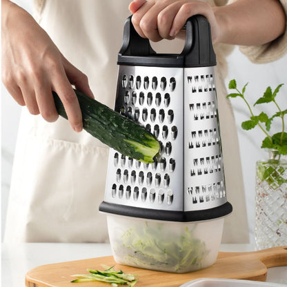 Person using a box grater to shred a cucumber on a wooden cutting board.