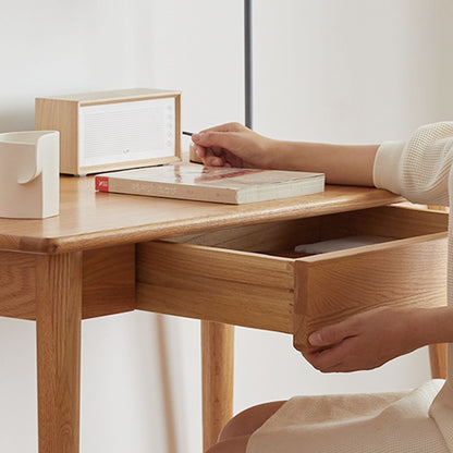 Person opening a wooden drawer on a desk with a minimal background