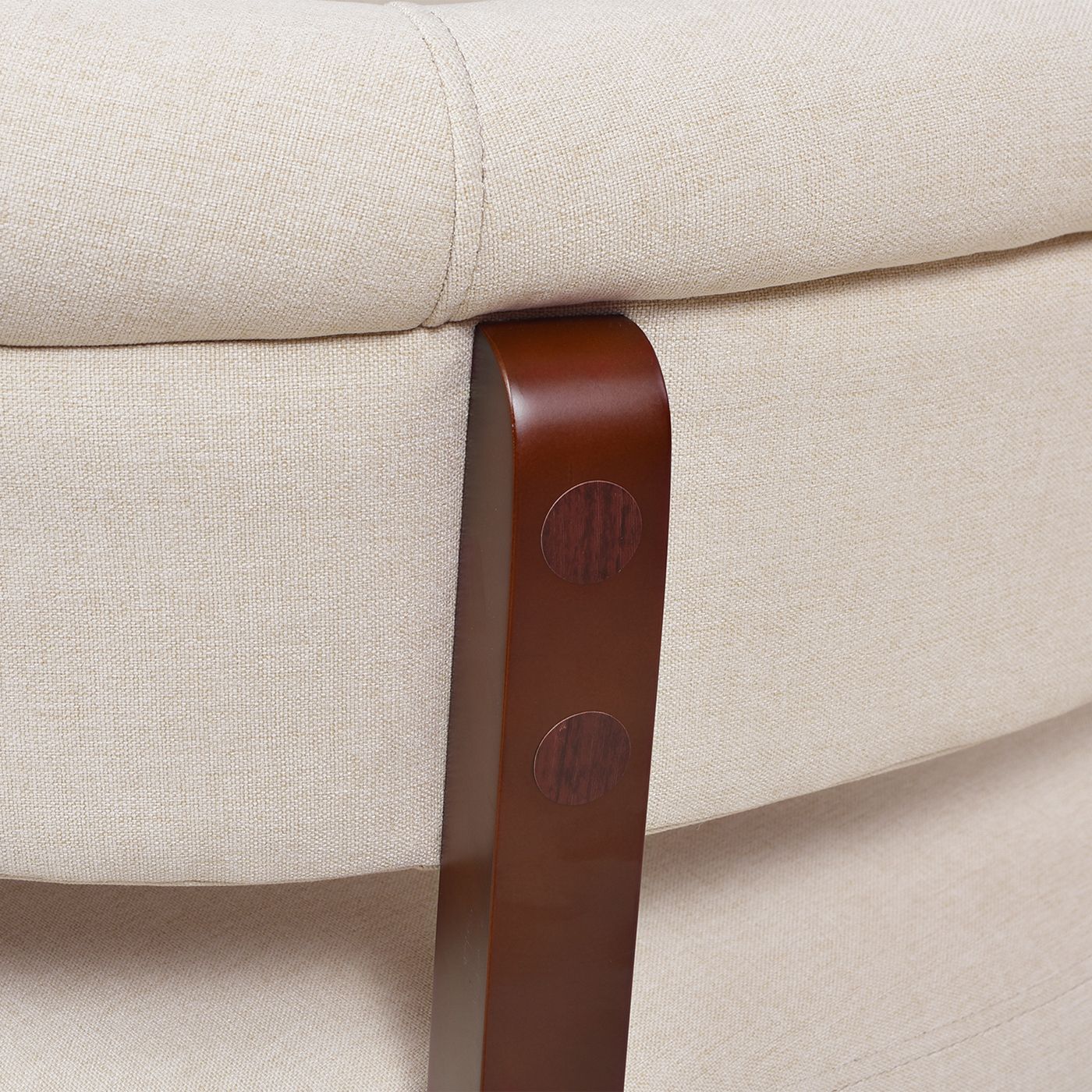 Close-up of a beige sofa with a brown leather armrest