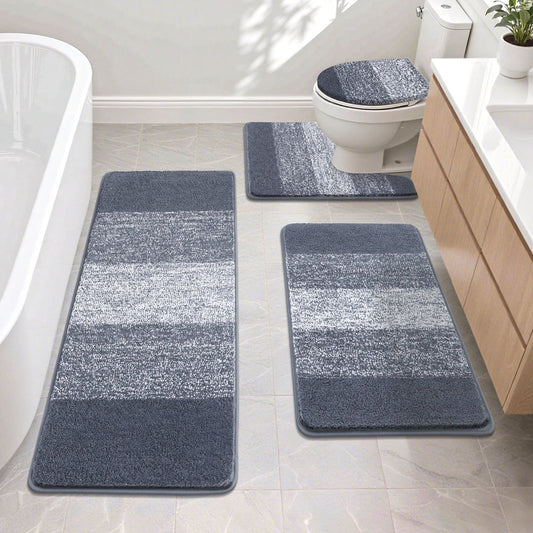 Bathroom set with striped blue and gray bath mats on a tiled floor.